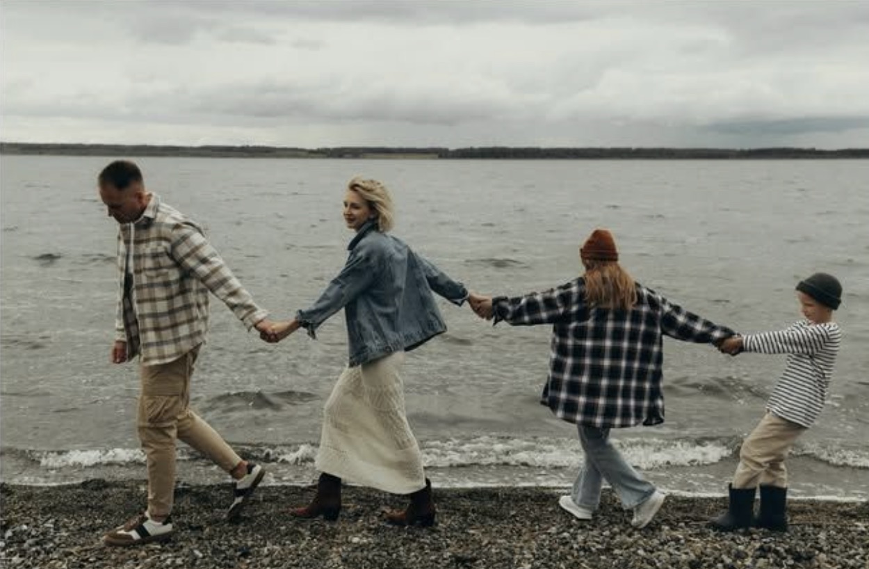 A family walking hand in hand along the shore